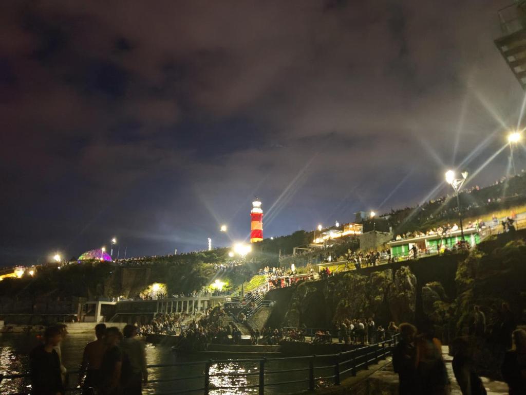 a lighthouse at night with a crowd of people at City Centre Room in Plymouth