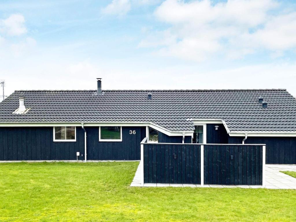 Egense的住宿－8 person holiday home in Storvorde，前面有黑色围栏的房子
