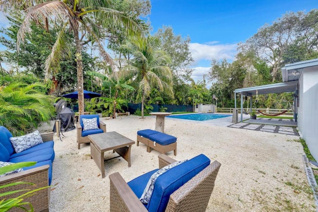 a patio with chairs and a table and a pool at Farmhouse Miami in Miami