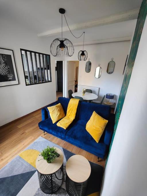 - un salon avec un canapé bleu et des oreillers jaunes dans l'établissement Charmant T2 atypique, rénové, à Béziers