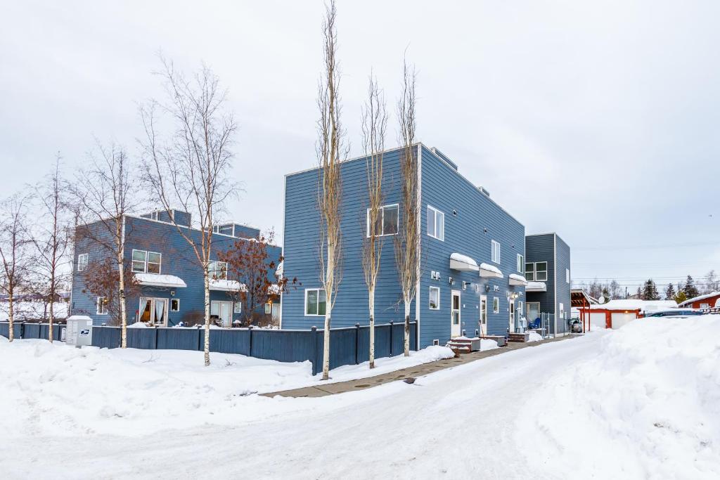 a blue building on the side of a snow covered street at Harmony Hills #229 in Anchorage