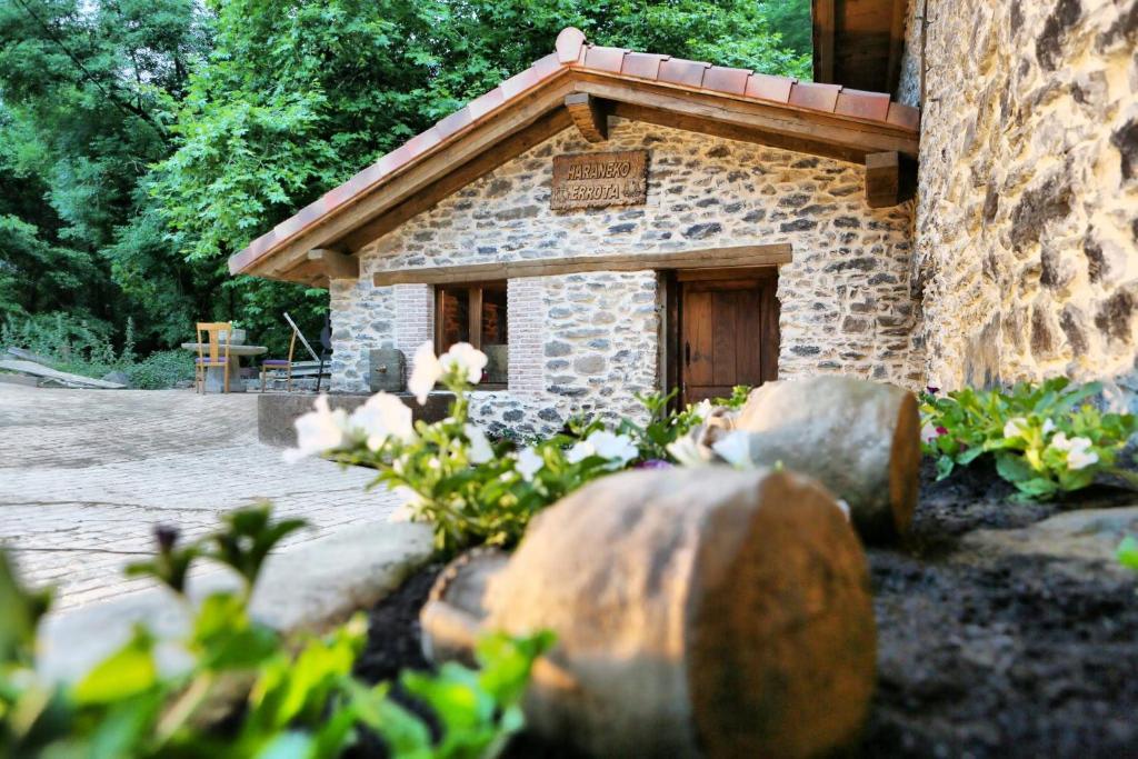 un pequeño edificio de piedra con un cartel. en Haraneko errota, en Chávarri