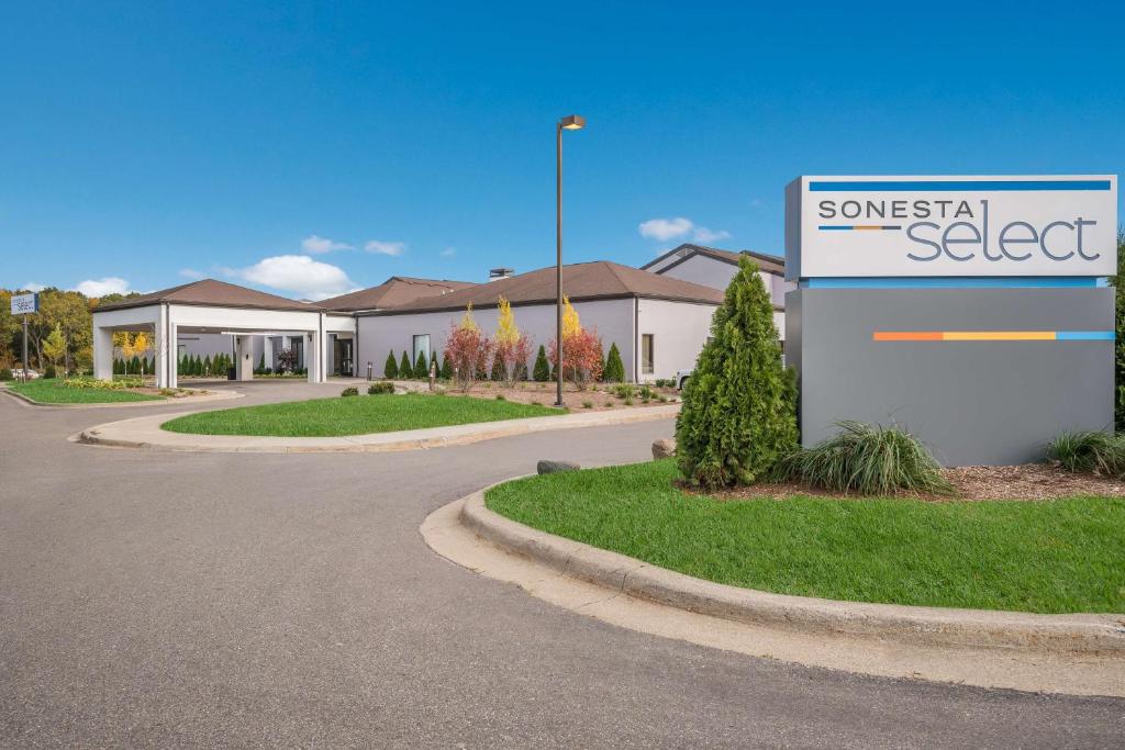 a building with a sign in front of a street at Sonesta Select Detroit Auburn Hills in Auburn Hills