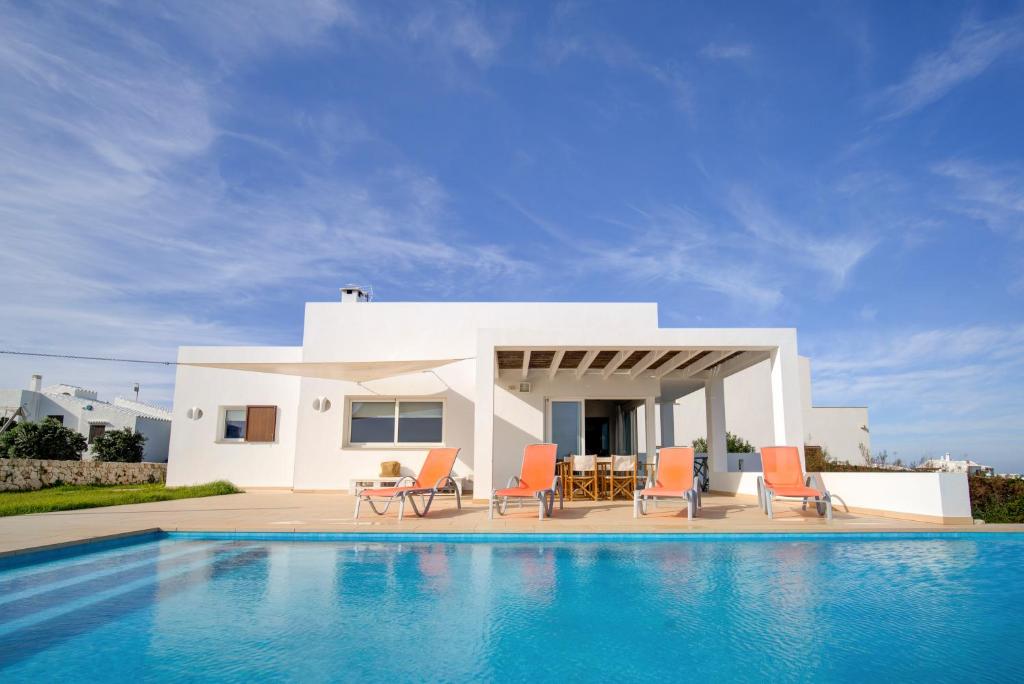 a villa with a swimming pool in front of a house at Villa Mercedes in Cala Morell