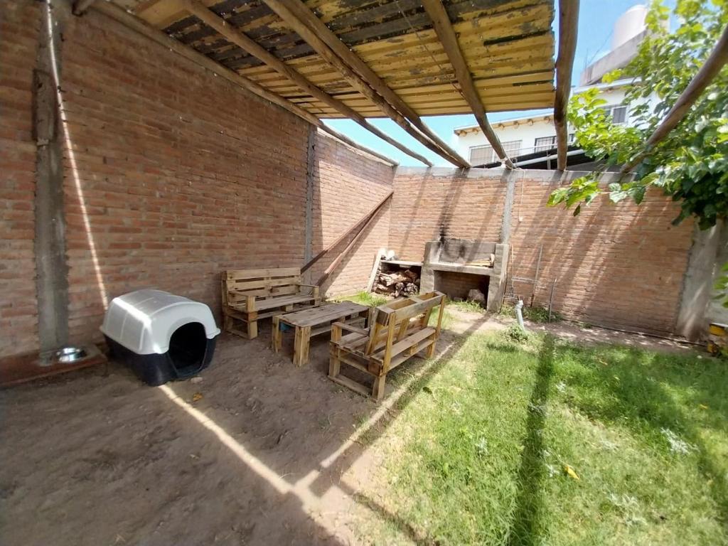 un patio al aire libre con sillas, una parrilla y una pared de ladrillo en departamento en san rafael mendoza en San Rafael