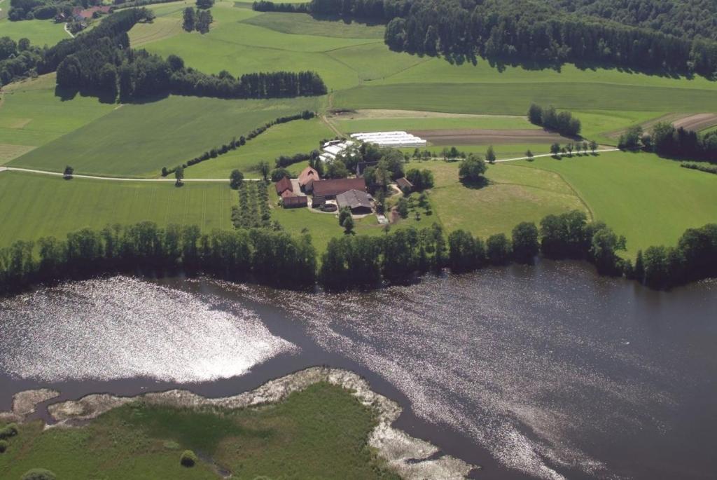 an aerial view of a house next to a lake at Rösslerhof Ferienwohnung Stiller Bach 