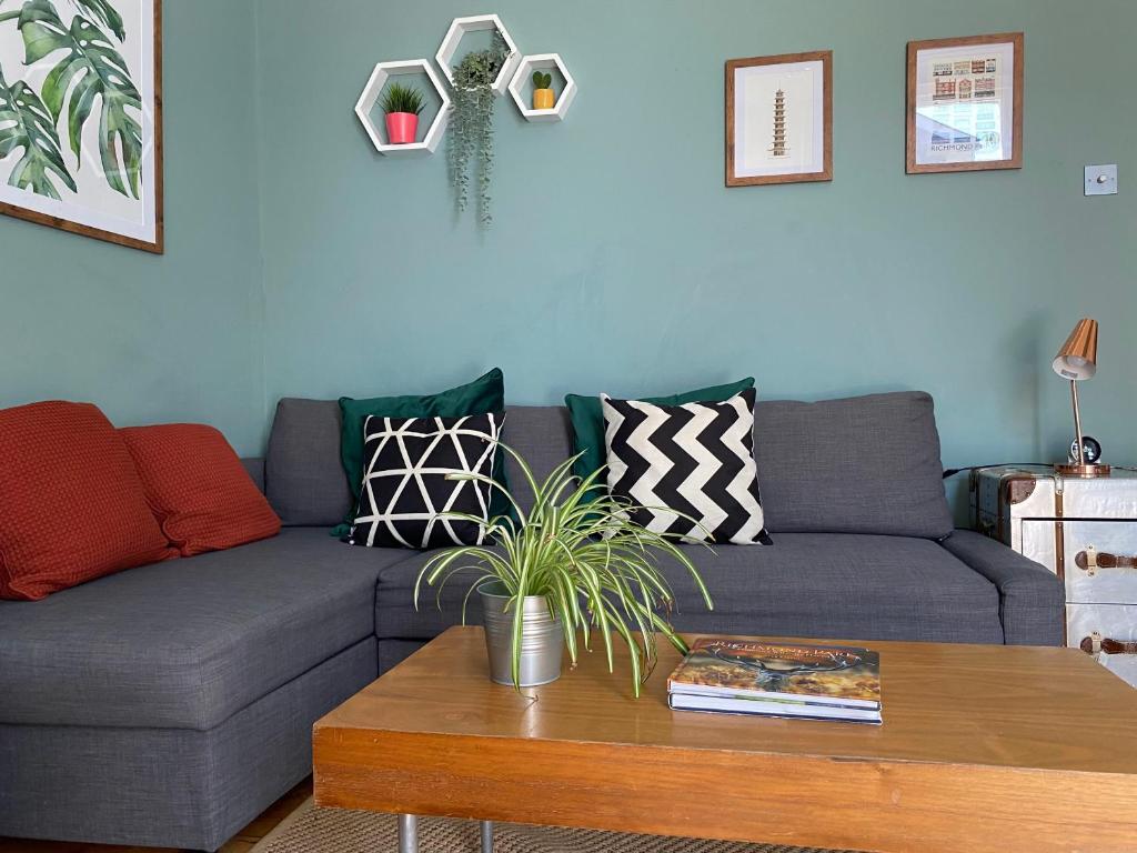 a living room with a couch and a coffee table at By the Pagoda- cozy garden flat by Richmond & Kew Gardens in Kew Gardens