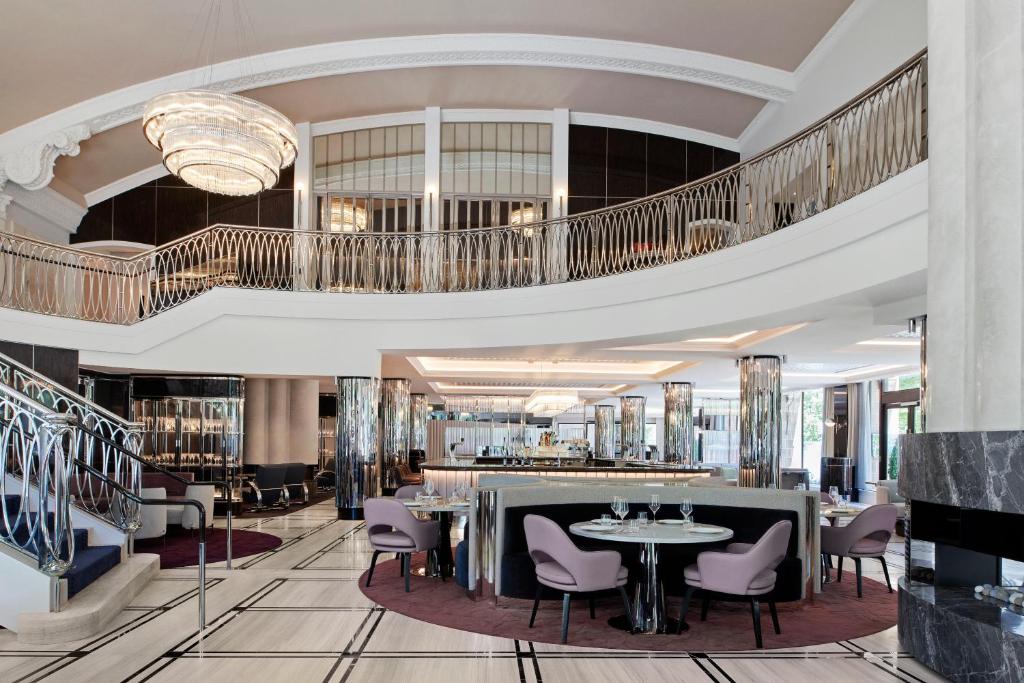 um átrio de um hotel com mesas e cadeiras em The Royce em Melbourne