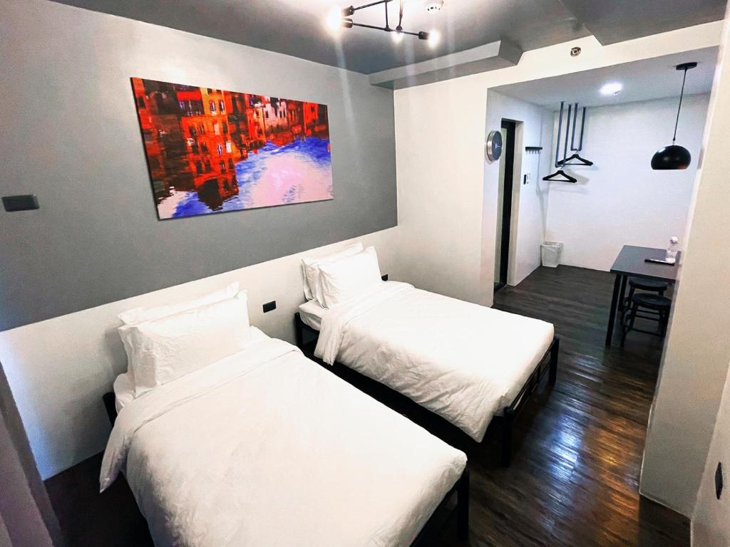 dwa łóżka w pokoju z obrazem na ścianie w obiekcie mySTAY Hotel BGC North w mieście Manila