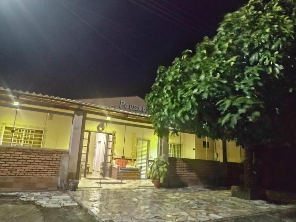 un edificio con un albero di fronte ad esso di notte di Pousada Refúgio da Chapada a Cavalcante