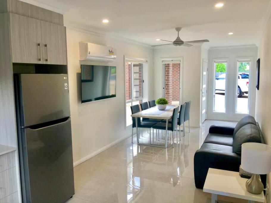 eine Küche und ein Wohnzimmer mit einer Couch und einem Tisch in der Unterkunft Wagga Apartments #2! in Wagga Wagga
