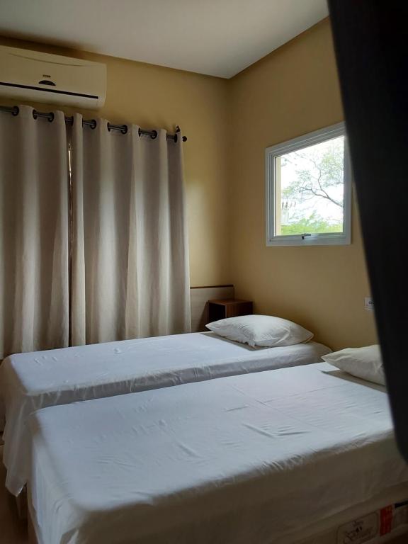 2 Betten in einem Schlafzimmer mit Fenster in der Unterkunft Chácara aconchego do Valle in Petrolina