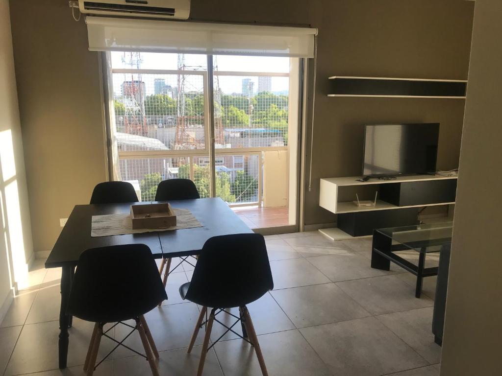 uma sala de jantar com mesa e cadeiras e uma grande janela em Departamento nuevo em Mendoza