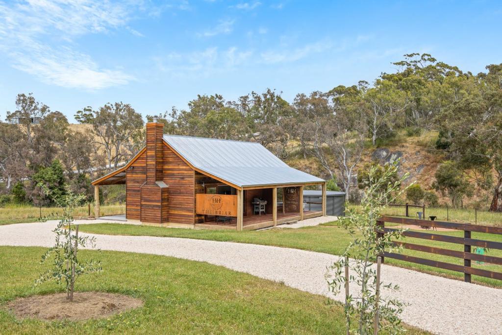 a log cabin with a metal roof and a fence at Grandview Accommodation - Hideaway Huts in Dawesley