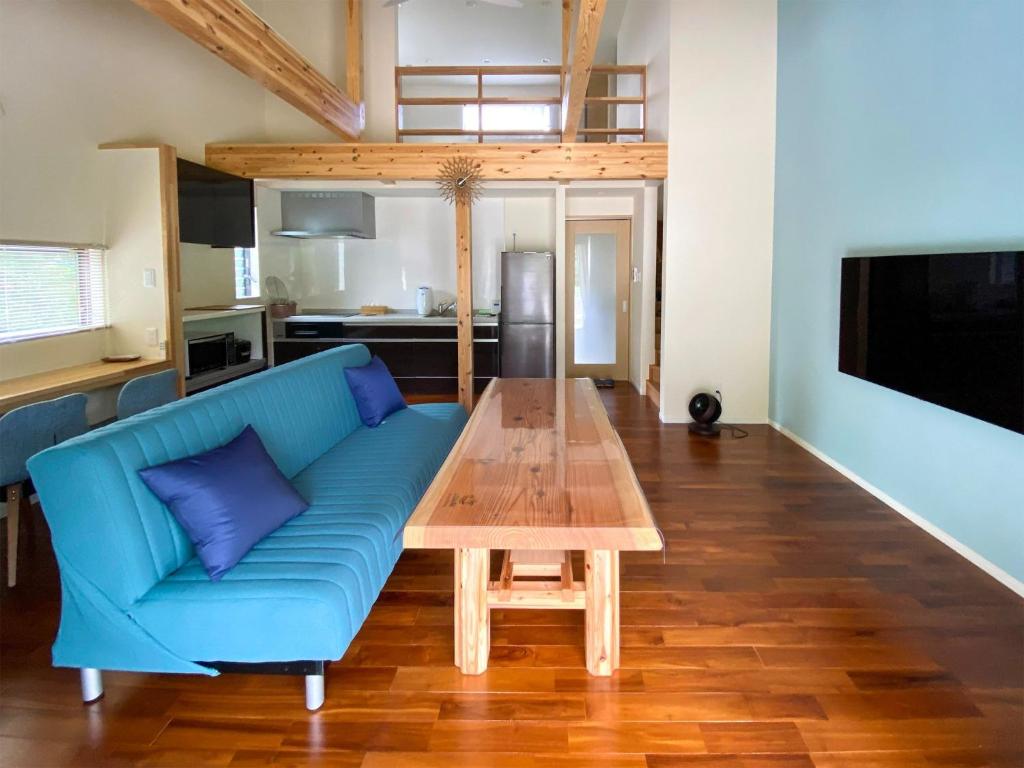 un soggiorno con divano blu e tavolo in legno di Yonehara Beach Stay LUANA - Vacation STAY 38711v a Fukai