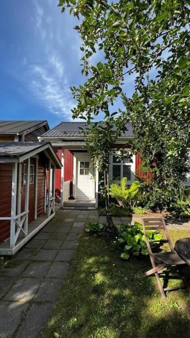 a yard with two houses and a house with a chair at Apartment Wanha Kartano in Kokkola
