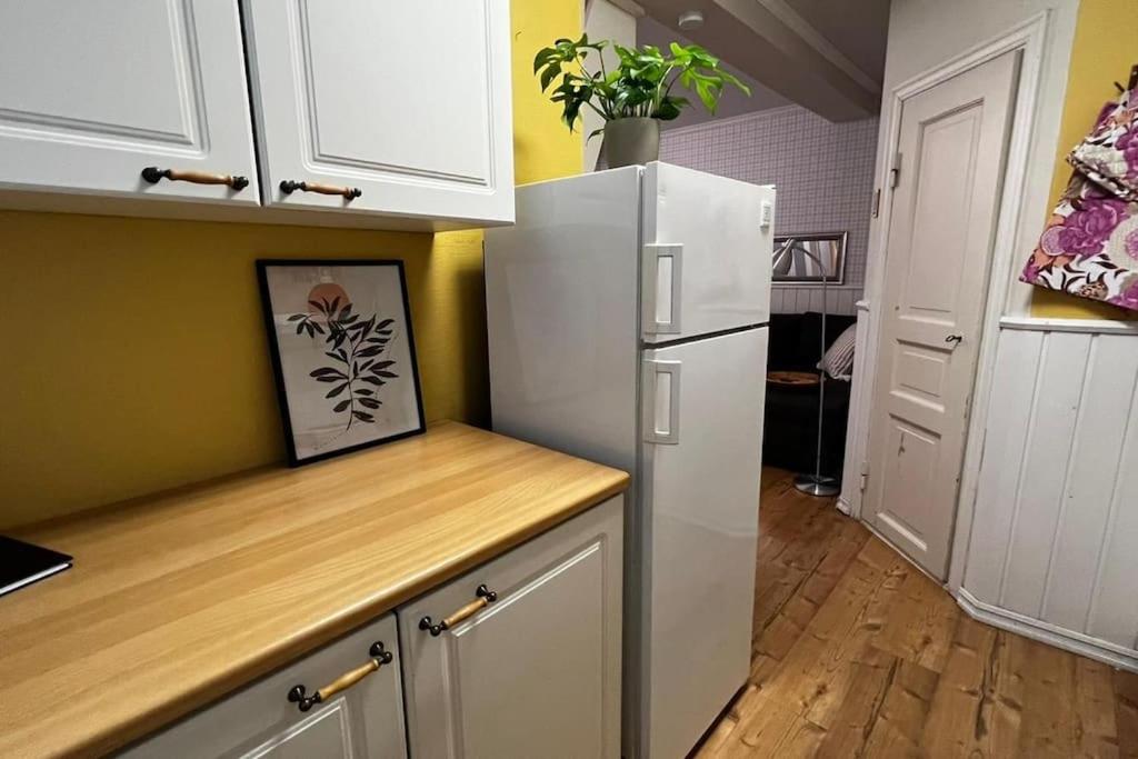a kitchen with white cabinets and a white refrigerator at Apartment Wanha Kartano in Kokkola