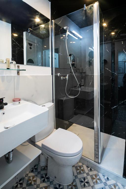 a bathroom with a toilet and a shower and a sink at Apartments WS Tour Eiffel - Laos in Paris