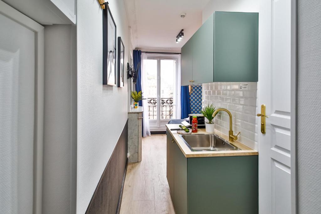 a kitchen with green cabinets and a sink at Apartments WS Tour Eiffel - Laos in Paris