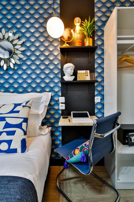 a bedroom with a bed and a desk with a laptop at Apartments WS Tour Eiffel - Laos in Paris