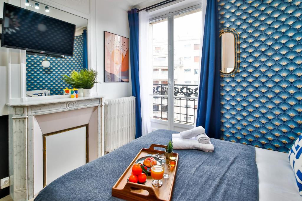 a tray of fruit on a bed in a room at Apartments WS Tour Eiffel - Laos in Paris