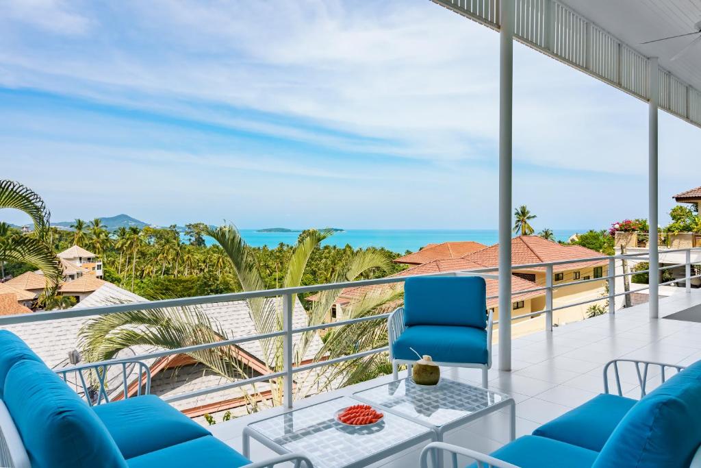 a balcony with blue chairs and a view of the ocean at Villa Alba in Chaweng Noi Beach