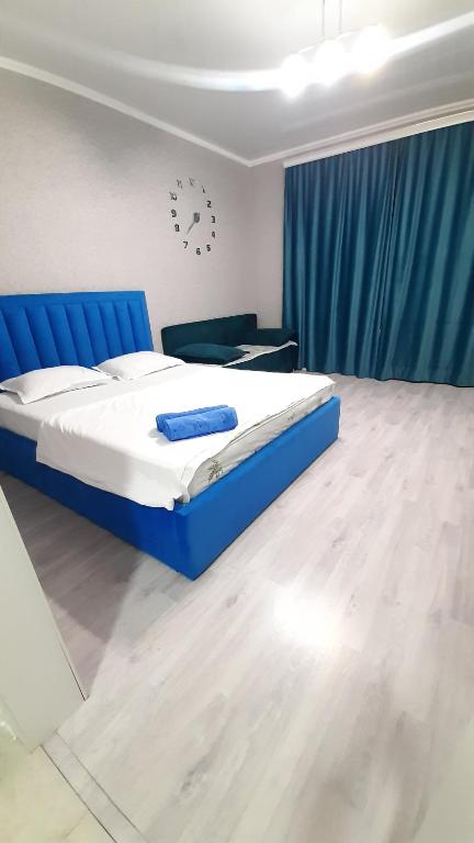 a bedroom with a bed with a blue bed frame at Жк ривьера in Kokshetau