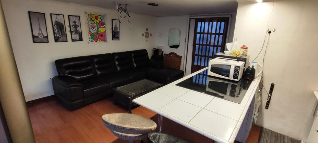a living room with a couch and a microwave at Casa de Verano in Iquique