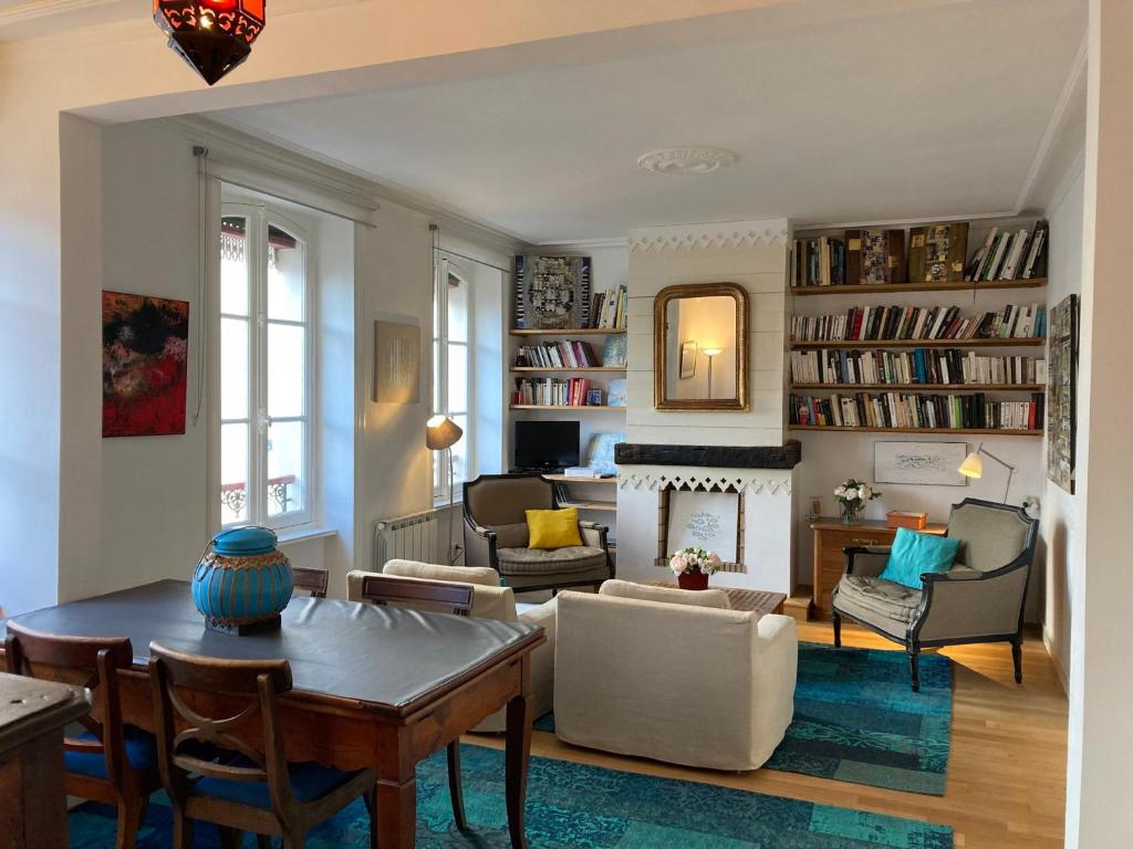 salon ze stołem i krzesłami oraz kominkiem w obiekcie Appartement élégant 3* au coeur de Le Palais, 2 chambres, proche commerces et plage - FR-1-418-197 w mieście Le Palais