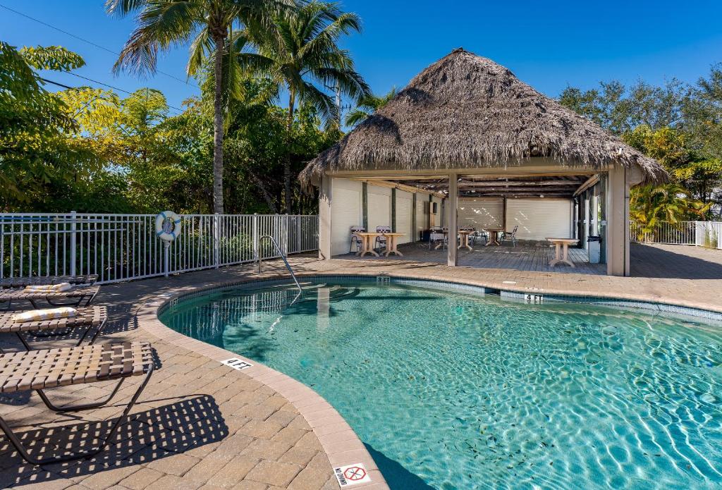 uma piscina de resort com telhado de palha em - The Bonita Paddle A202 - Beautiful Bonita Springs Condo with Mother In Law Suite! condo em Bonita Springs