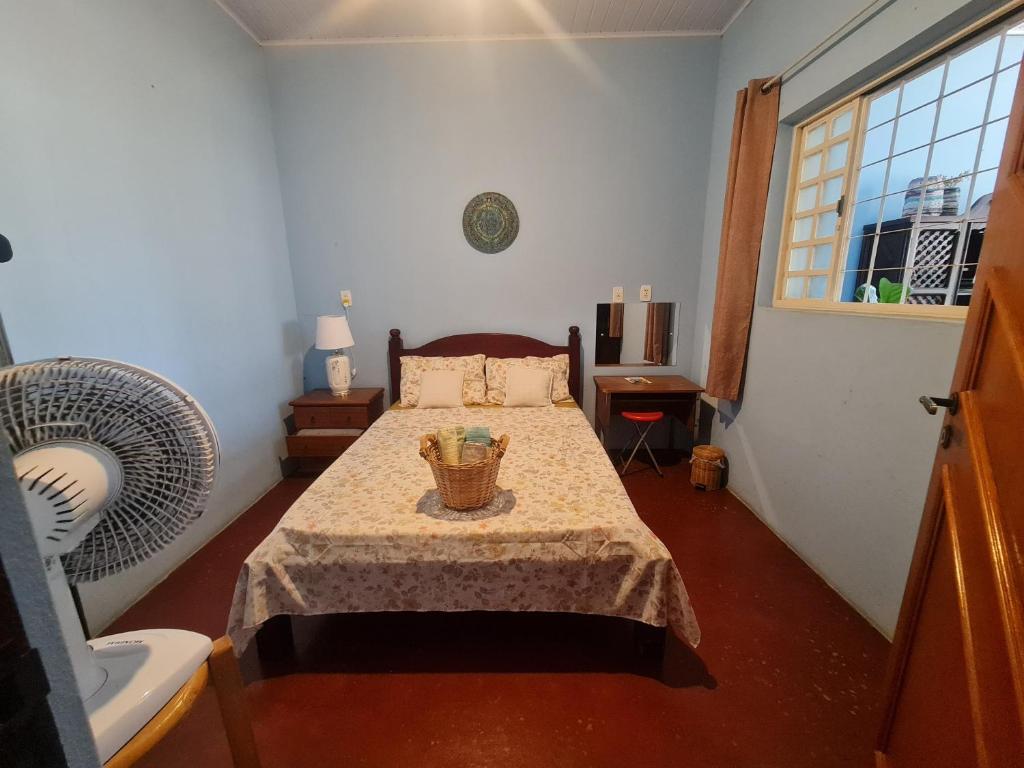 a bedroom with a bed with a table and a window at MAEVE Quarto Mata in Goiás