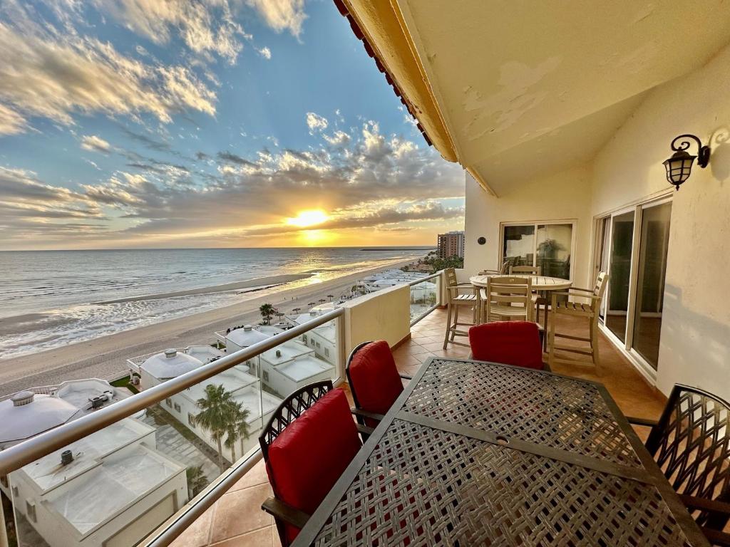 a balcony with a table and chairs and a view of the ocean at Spectacular 2 Bedroom Condo on Sandy Beach at Las Palmas Resort B-705 condo in Puerto Peñasco