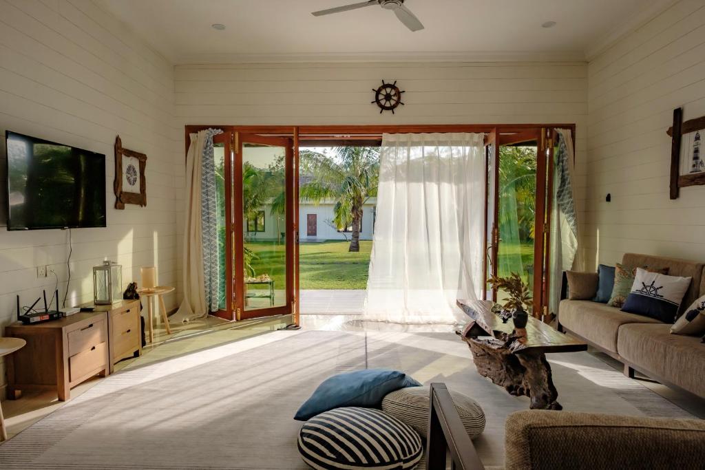 a living room with a couch and a sliding glass door at Sembilan Langkawi in Kampung Padang Masirat