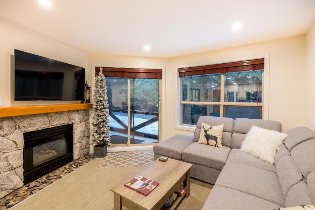 a living room with a couch and a fireplace at 116 Aspens in Whistler
