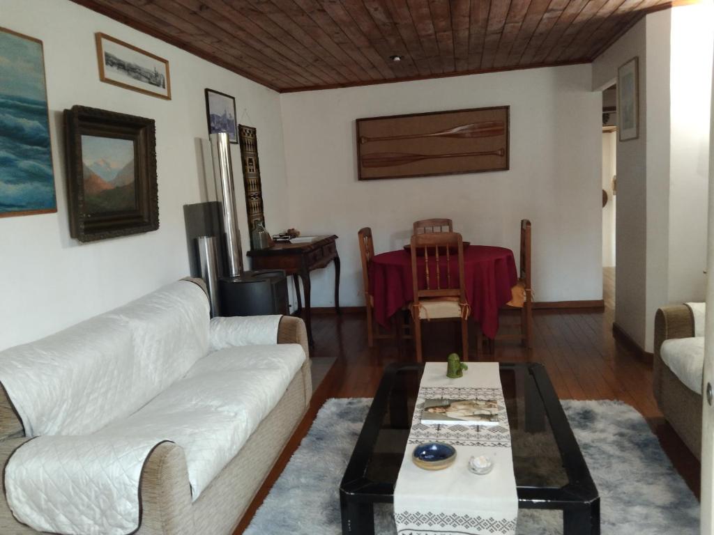 a living room with a white couch and a table at Cabaña acojedora in Zapallar