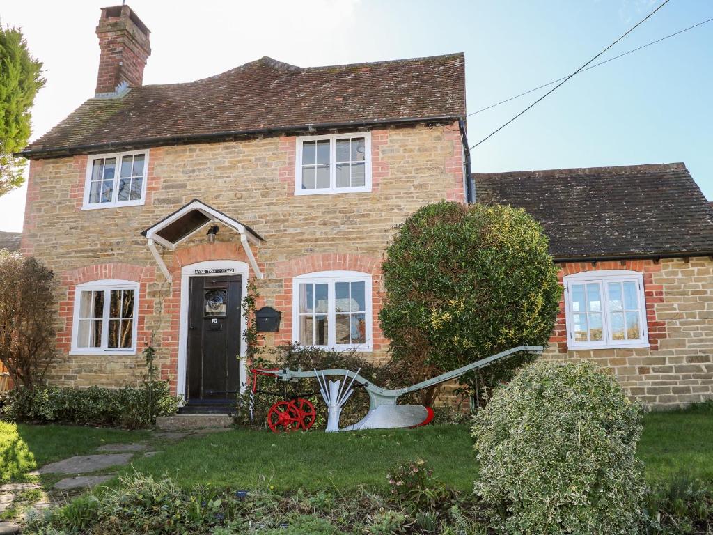 a brick house with a bike in the front yard at Apple Tree Cottage in Horsham