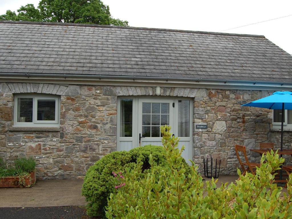 a stone cottage with a white door at Dryslwyn Cottage in Carmarthen