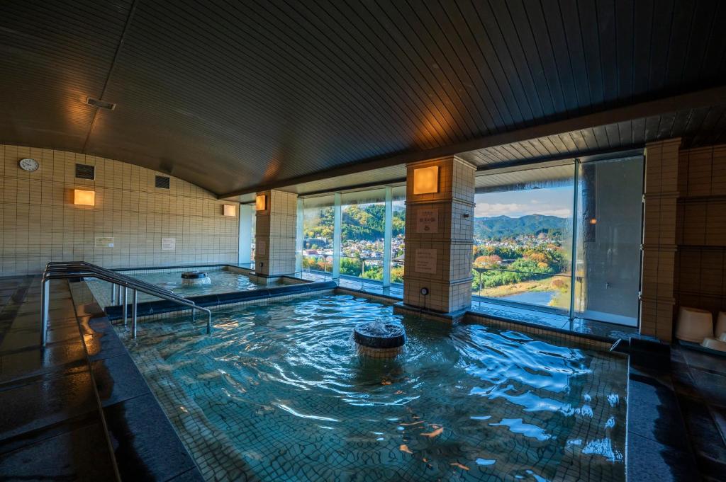 a large indoor swimming pool in a building at KAMENOI HOTEL Ome in Ome