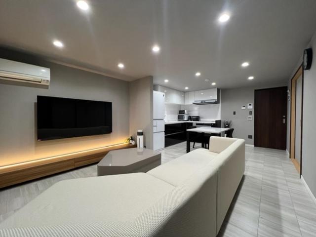 uma sala de estar com um sofá e uma televisão de ecrã plano em Platinum.Kiyomizu em Giommachi