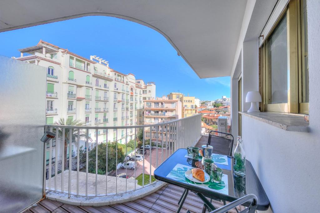 einen Balkon mit einem Tisch mit Essen drauf in der Unterkunft Le Bristol V - Happy Rentals in Juan-les-Pins