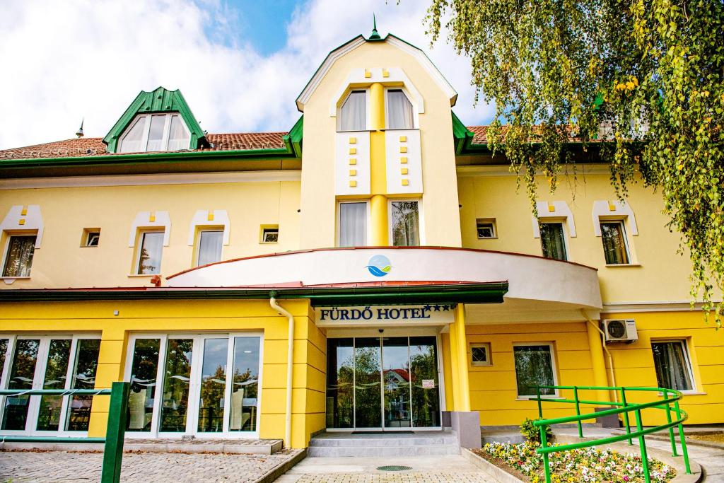 a yellow building with a sign that reads horizons hotel at Fürdő Hotel*** Zalakaros in Zalakaros