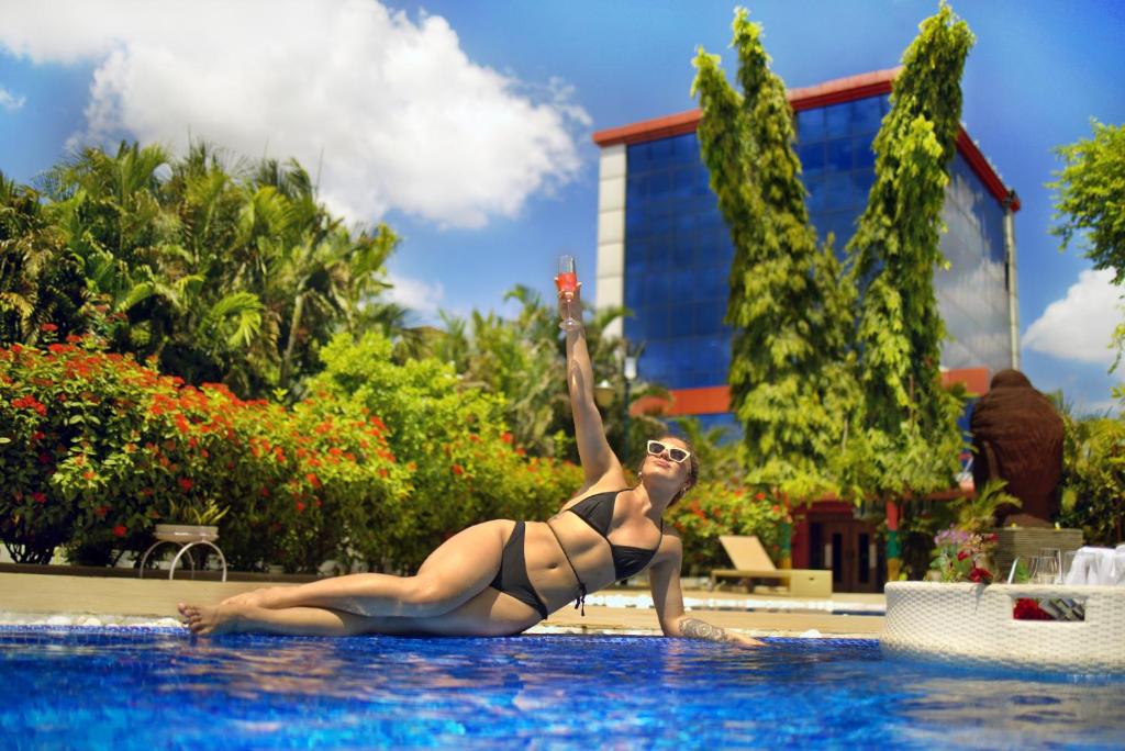 Una donna in bikini sdraiata in piscina di Sambodhi Retreat a Bodh Gaya