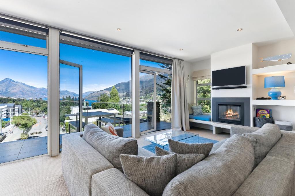 a living room with a couch and a fireplace at Diamond Villa - Lake Views, Central Location in Queenstown