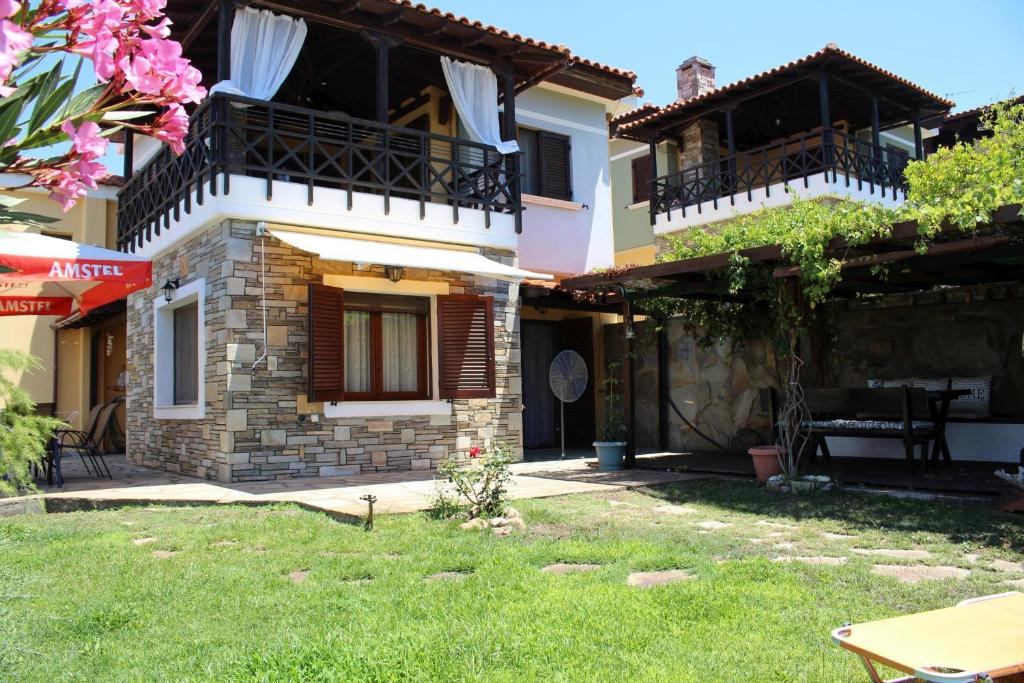 a house with two balconies and a yard at Miranta in Nikiti