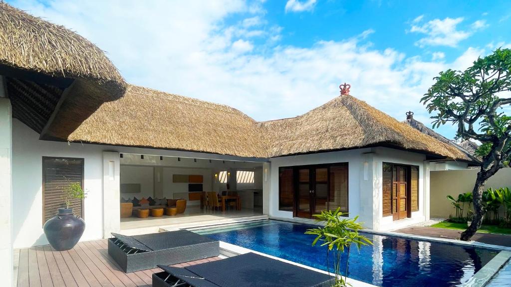 a house with a swimming pool in front of it at Bvilla Spa in Seminyak