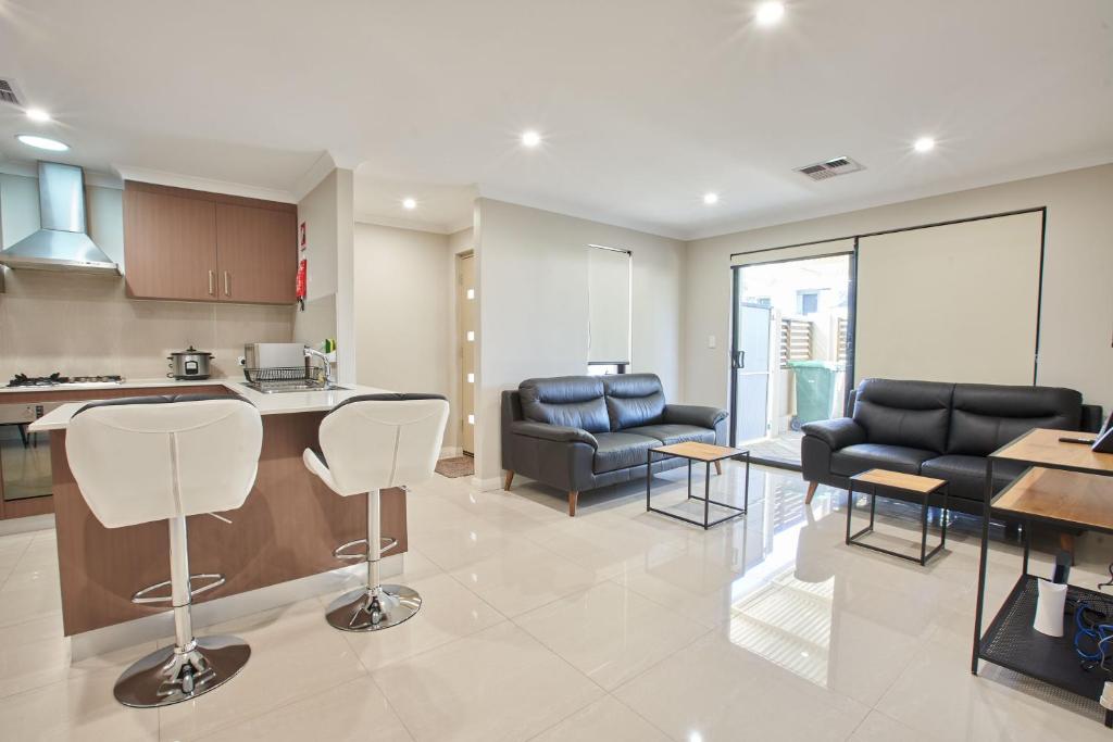a kitchen and living room with chairs and a table at Gorgeous Family House near Shops in Perth