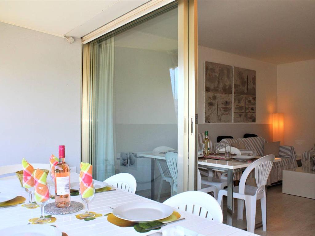 une salle à manger avec une table et des chaises blanches et une salle avec une table à manger dans l'établissement Moderne T3, 2 chambres, climatisé, parking, plage à pied - FR-1-252A-93, à Villeneuve-Loubet