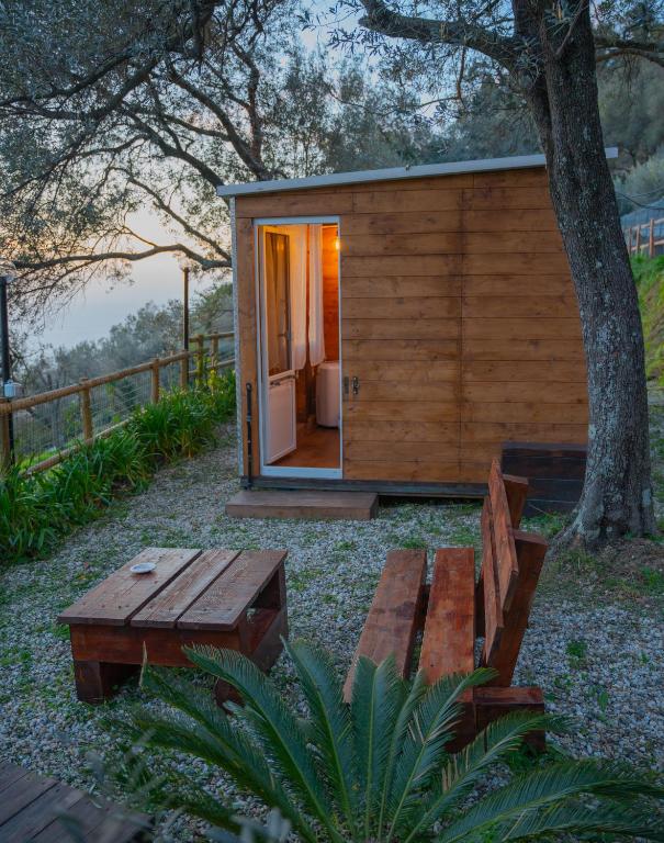 a small wooden cabin with a bench and a tree at Agriturismo S.Ilario in Genoa