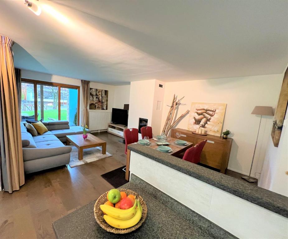 a living room with a couch and a table with a bowl of fruit at Walensee Apartment, Lakeside Dream in Unterterzen