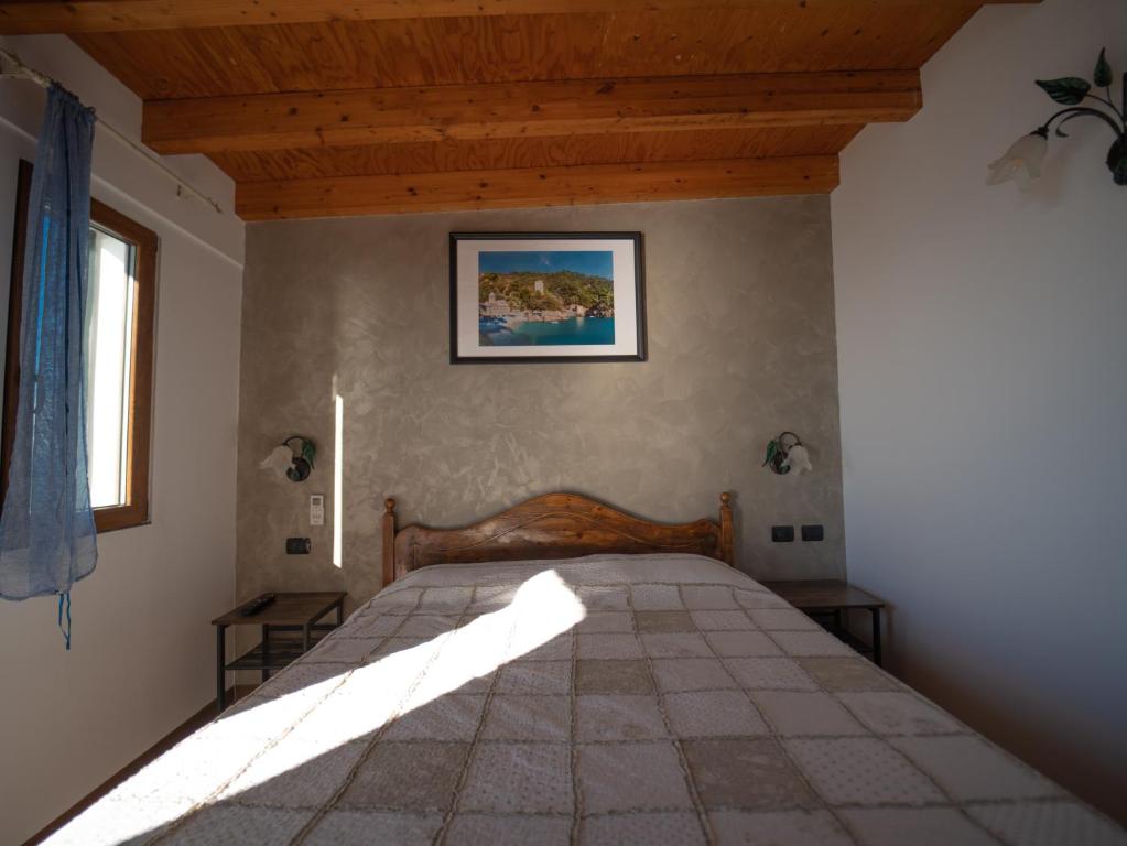 a bedroom with a large bed with a wooden ceiling at Agriturismo S.Ilario in Genoa